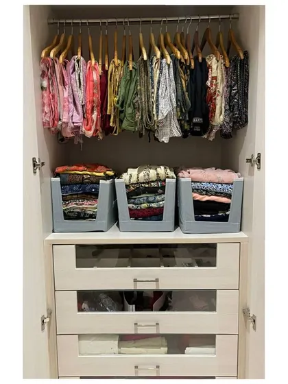 A great example of a functional wardrobe system. We hung the dressier items, used stackable bins for folded clothes, and utilized the glass-front drawers for smaller items.