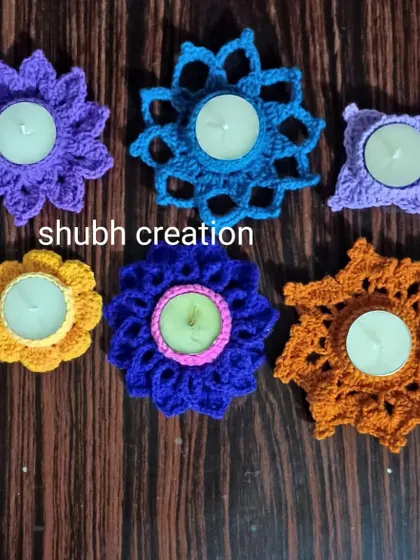 A set of six colorful, flower-shaped crochet candle holders, designed to hold small tea lights for a festive glow.