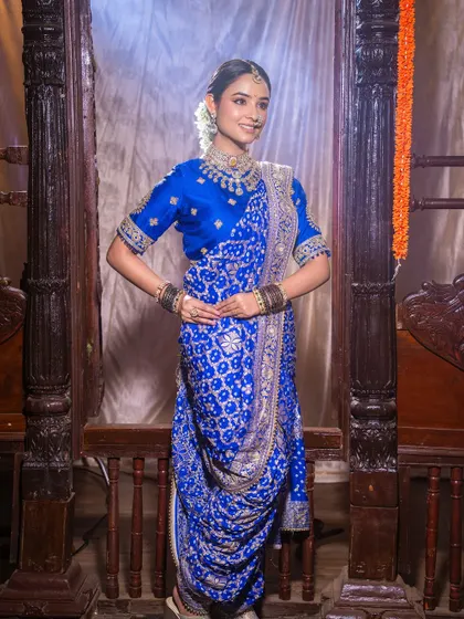 A full view of the royal blue Navari saree. The makeup is kept classic and graceful to complement the traditional draping and setting.