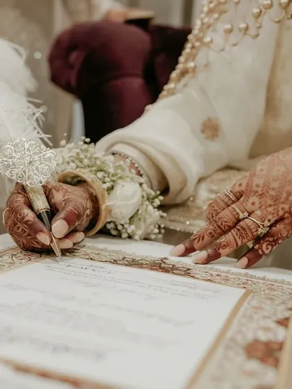 An identical shot to ID 16, showing the beautiful detail of the bride signing her Nikah contract.