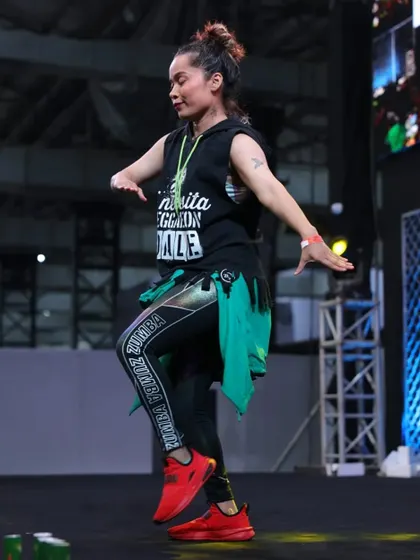A solo moment on the IHFF stage. This pose captures the grace and strength that dance fitness helps to build, combining artistry with athleticism.