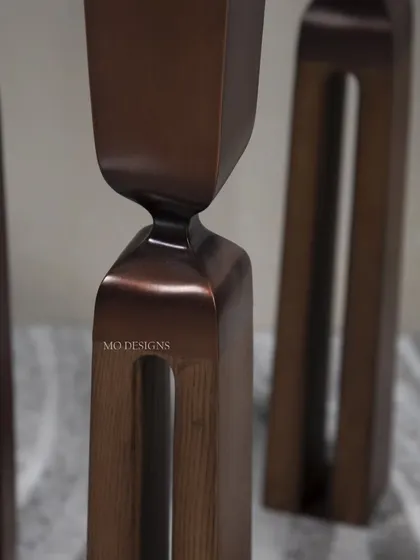 A close-up on the bronze-patina brass legs of our sculptural side table. The unique cut-out design and smooth finish highlight our commitment to creating furniture that is both functional and a work of art.