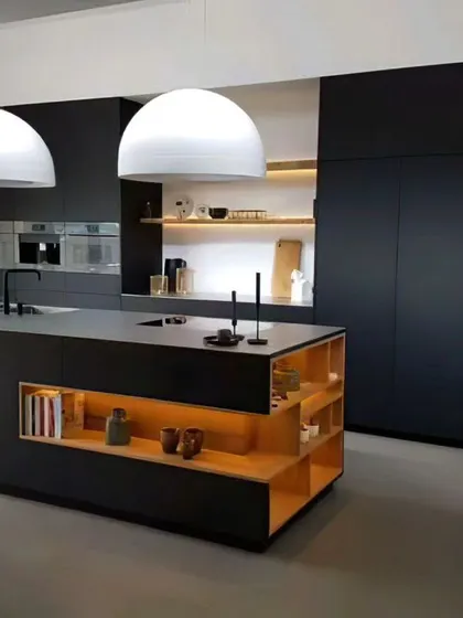 This ultra-modern kitchen features a large, matte black island with integrated shelving and warm wood accents. The handleless floor-to-ceiling cabinets create a seamless, monolithic look.