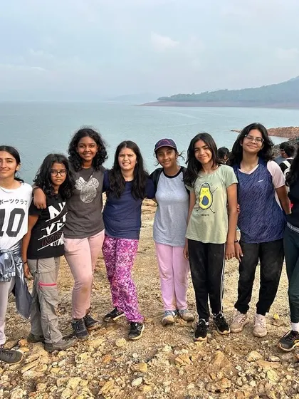 A group of campers stands together by the water, a testament to the friendships and bonds created at our camps.