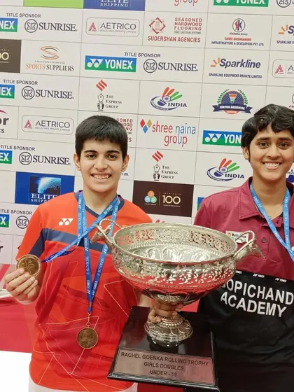 **A Champion's Smile.** Anmol Kharb with her partner, holding the impressive rolling trophy for the U-19 Girls' Doubles at the Krishna Khaitan Memorial tournament.