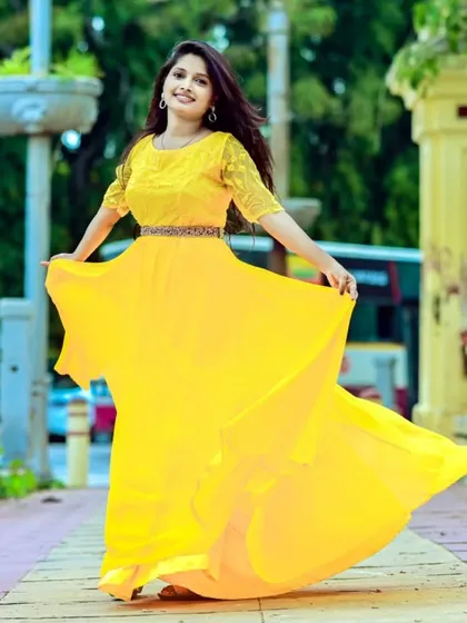 A happy client looking like a ray of sunshine in this bright yellow flowy gown. It's a perfect, cheerful outfit for a daytime event or a fun photoshoot.