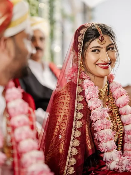 A candid moment from the ceremony, capturing the bride's joyful smile. Her makeup is designed to last through all the emotions of the day.