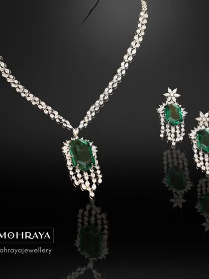 An exquisite emerald and diamond necklace set, professionally shot to highlight its brilliant shine and deep green color. A true luxury piece.