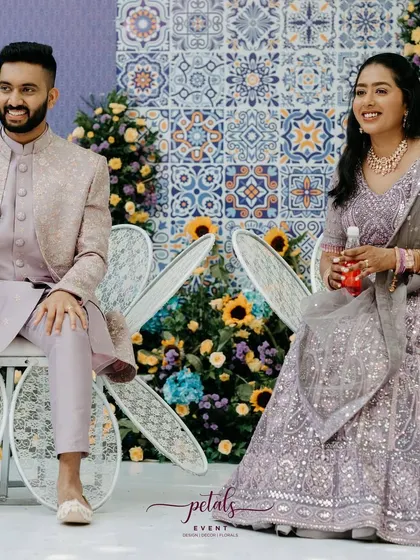 The happy couple enjoying their Mediterranean-themed Haldi. The vibrant backdrop and beautiful flowers create the perfect setting for their celebration.