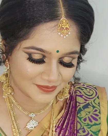 Another angle of this gorgeous South Indian bridal makeup. The focus is on the eyes, with dramatic lashes and gold eyeshadow that catches the light beautifully.