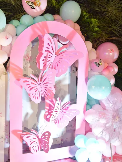 Another angle of the pink butterfly panel, surrounded by a soft pink and mint green balloon garland.