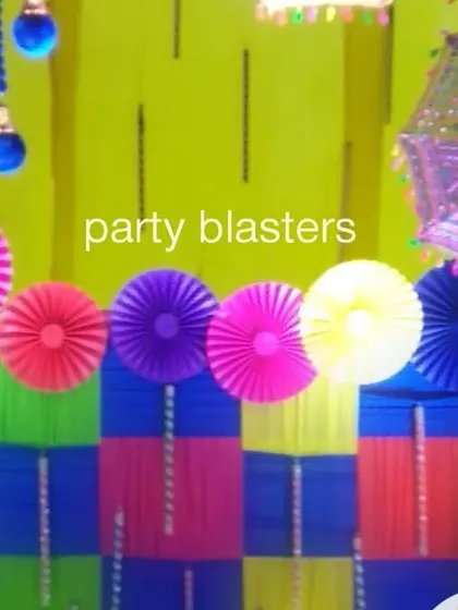 Attention to detail is key in our themed decor. This photo shows a close-up of a Dandiya party backdrop, featuring a combination of colorful woven mats, paper pinwheels, and a traditional decorative umbrella.