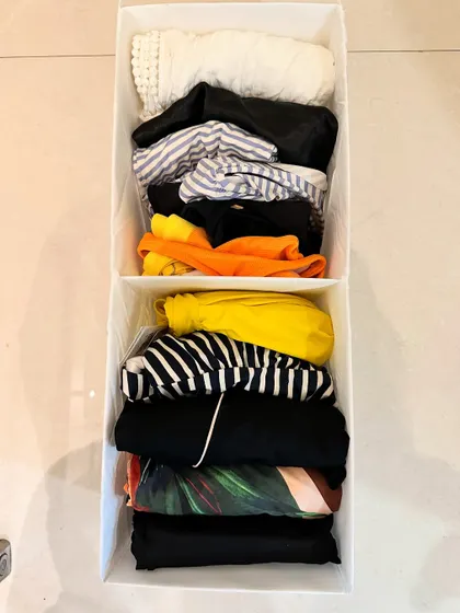 File-folded swimwear stored in a divided bin. This is the perfect way to keep your vacation essentials organized and easy to pack.