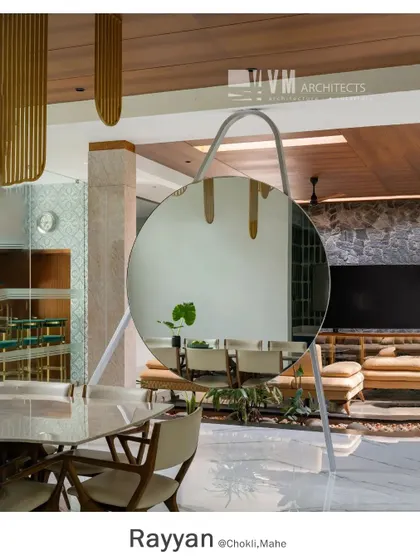 The oversized circular mirror in the Rayyan dining hall acts as a sculptural element, reflecting the living space and adding depth and modern elegance to the room.