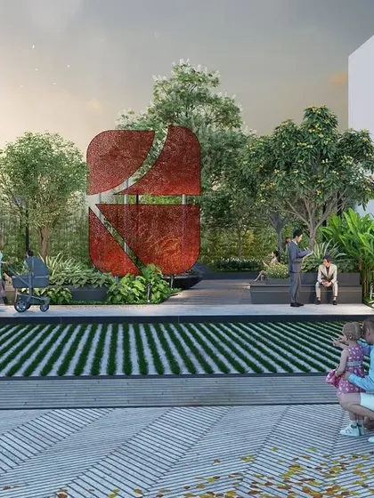 This view of a Suyug community space highlights the use of a large, abstract sculpture as a central gathering point. The surrounding landscape design includes striped grass pavers and ample seating, creating a dynamic and modern park for residents.