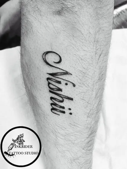 A clean, bold name tattoo on the leg. We ensure perfect clarity and style, no matter the placement.