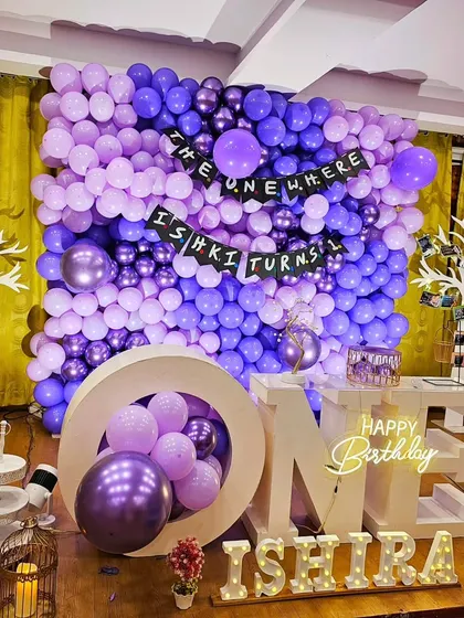 A different angle of the "Friends" themed party, showing the "ONE" marquee letters and other decorative props.