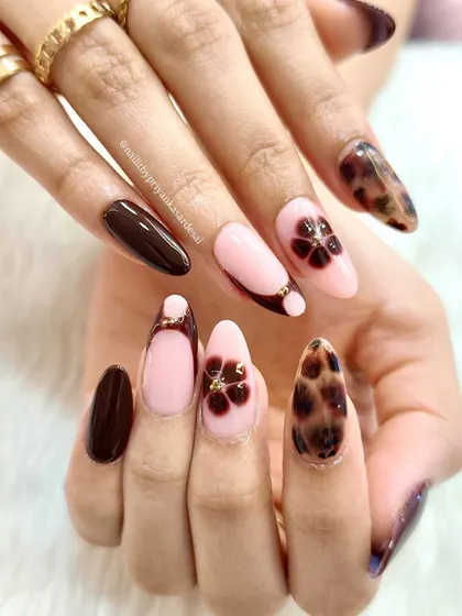 Flower power meets fierce print. This sweet-meets-sassy manicure combines a dark tortoiseshell print with soft pink nails and delicate floral accents.