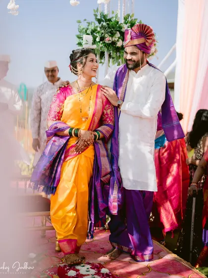 A candid moment on the mandap, with the groom placing his hand on the bride's shoulder.
