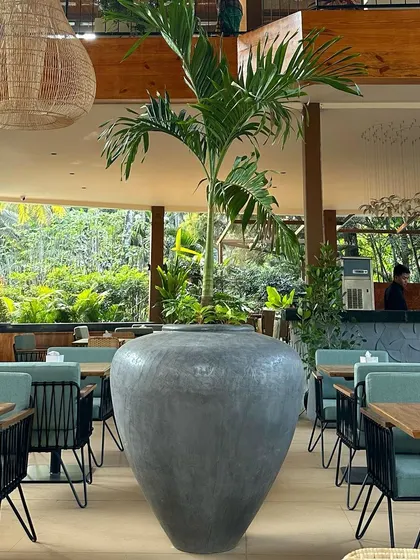 The 'Luhur' planter, standing tall at 110 CM, serves as a beautiful home for a large tree in this modern restaurant space.