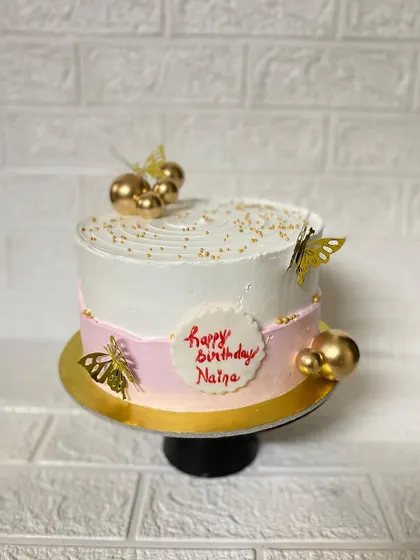 A full view of the pink and white butterfly cake, perfect for Naina's birthday.