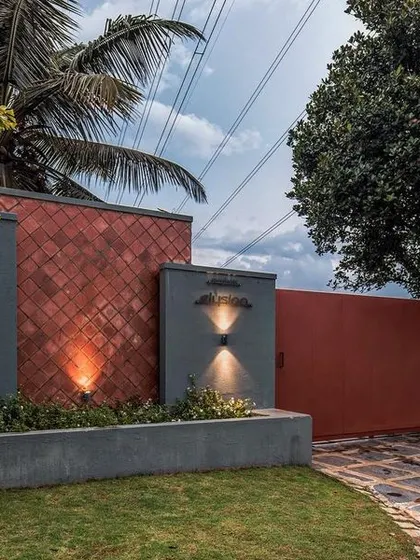 The entrance gate design for The Grey Grotto, combining textured grey walls with earthy red tones and subtle lighting to create a welcoming first impression.