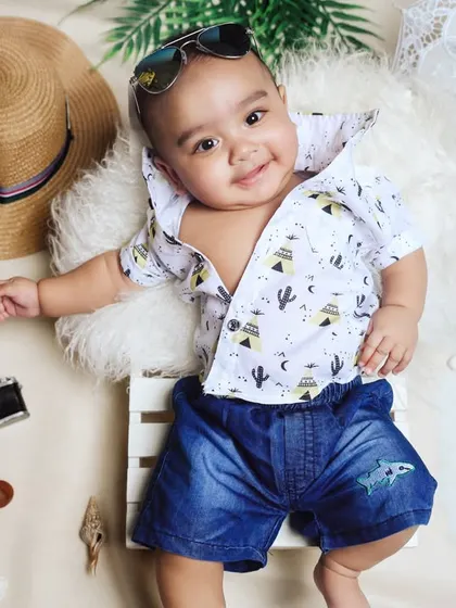 Bringing the beach to our Bangalore studio. This creative setup includes real sand, a tiny deck chair, and summer accessories like a straw hat and sunglasses for a fun and stylish toddler photo session.