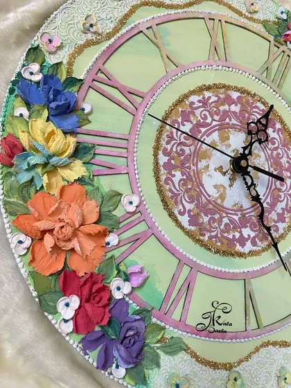 This angle of the green clock shows the other side of the floral arrangement, demonstrating the balanced composition and the variety of colors used.