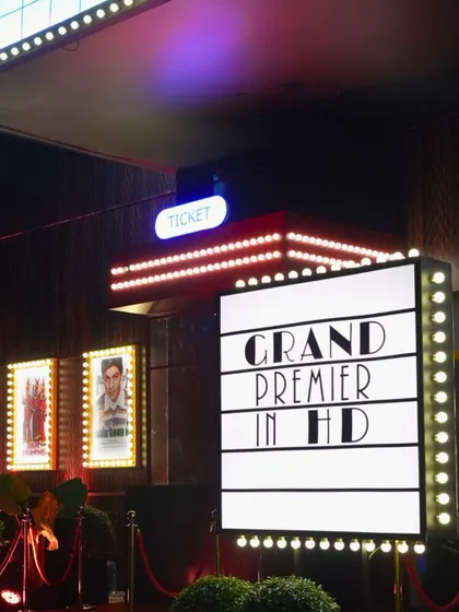 The grand entrance to a Bollywood-themed Sangeet, complete with a ticket counter and movie posters. We love bringing creative and personalized concepts to life.