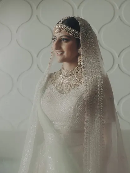 A bridal portrait that feels both grand and intimate. The bride, in her ethereal white lehenga, looks serene and beautiful, ready for her big day at the Taj Mahal Palace.