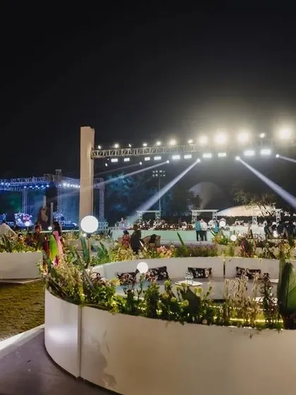 The guest seating area is just as important as the main stage. Here, we designed curved, modern white lounge seating within planters to create an elegant and comfortable space for guests near the entrance.