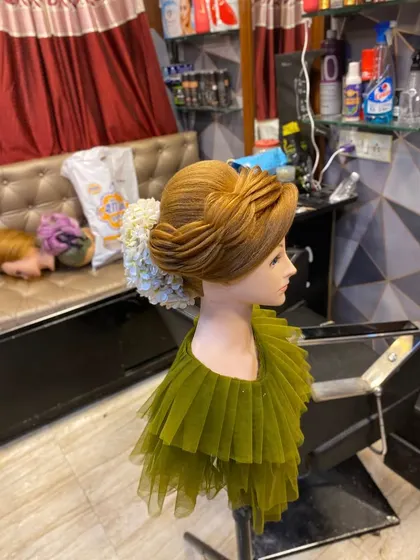 A side profile of the sculptural updo, highlighting the layered effect and the smooth, polished finish that is essential for advanced hairstyling.
