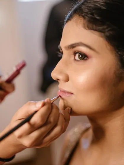 A behind-the-scenes shot of the final lip application. Every detail is perfected to ensure the bride looks and feels her absolute best.