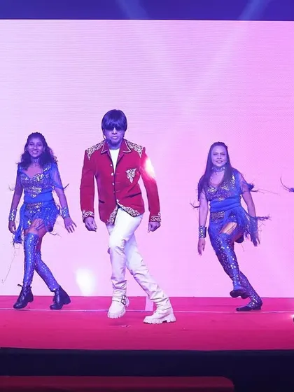 A performance in a red jacket and white pants, with my dancers in sparkling blue costumes. We use costume changes to keep the show visually exciting.