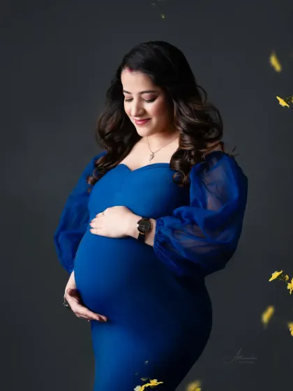 A portrait of pure elegance. This mom-to-be is glowing in a royal blue bodycon gown with sheer puff sleeves, a perfect choice for a classic and sophisticated look.