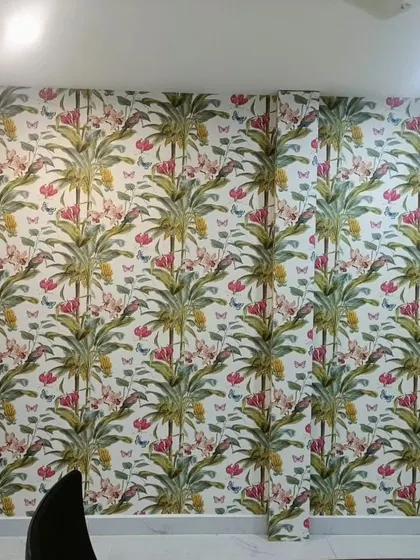 A room with a colorful tropical wallpaper featuring palm trees, flowers, and butterflies, creating a cheerful and lively atmosphere.