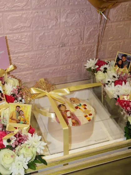 A sweet anniversary celebration hamper centered around a custom bento cake. We included photos of the couple and fresh flowers to create a truly personal and heartfelt gift.