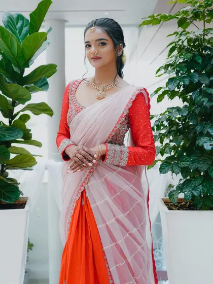A client looking elegant in her custom red and pink lehenga-saree. The heavily embroidered blouse is the centerpiece of this beautiful ensemble.