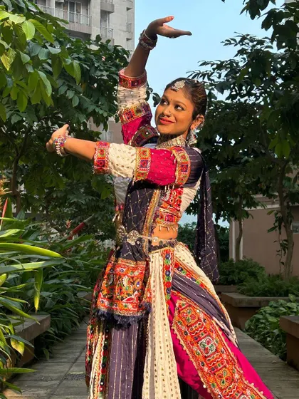 A dance pose that shows the flow and structure of this unique dhoti-style Garba outfit, perfect for someone wanting to try something different.