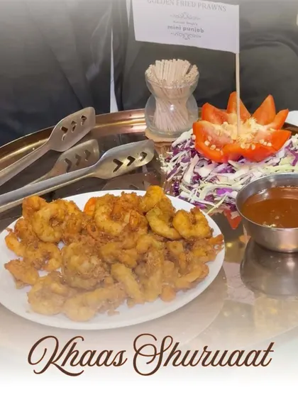 A 'Khaas Shuruaat' or special beginning, with a platter of Golden Fried Prawns. This dish is a favourite for its crispy texture and succulent flavour, making it a standout appetizer.