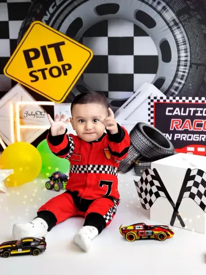 Pointing to the finish line. This little racer's personality shines through in this action-packed and colorful first birthday photo.