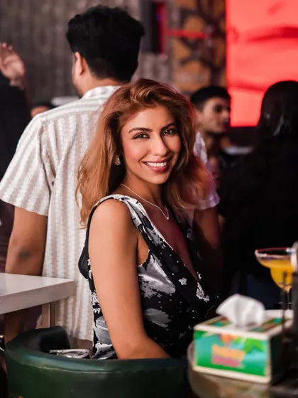 A guest smiling from her table, enjoying the ambiance.