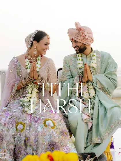 A formal portrait of the couple during their beach wedding, joining their hands in a 'namaste' gesture.