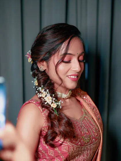 A close-up of the Haldi makeup, featuring soft pink eyeshadow and a beautiful floral braid.