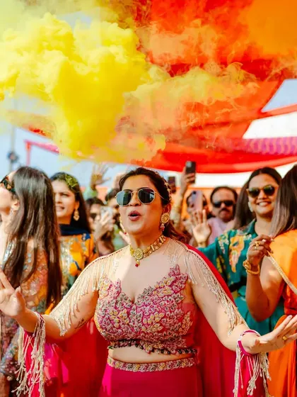 The bride's grand entrance at her Haldi, surrounded by friends and colorful smoke bombs, creating a spectacular and energetic start to the celebration.