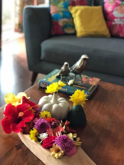 A beautiful centerpiece created with fresh-cut flowers from the garden, including red Hibiscus and colorful Zinnias. Bringing flowers indoors is a wonderful way to enjoy their beauty up close.