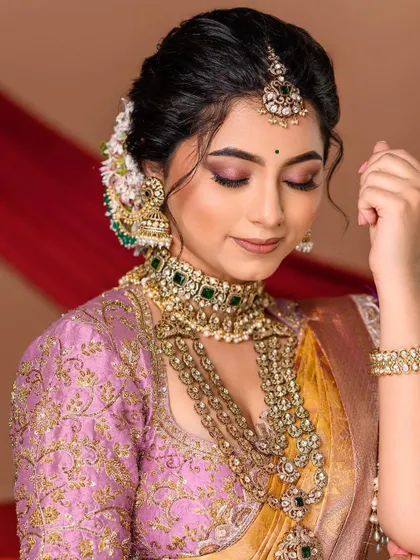 Soft, elegant, and timeless. This portrait showcases a beautiful engagement look, with a focus on the intricate details of the jewelry and the soft, romantic makeup. The pastel color palette adds a modern touch to the traditional attire.