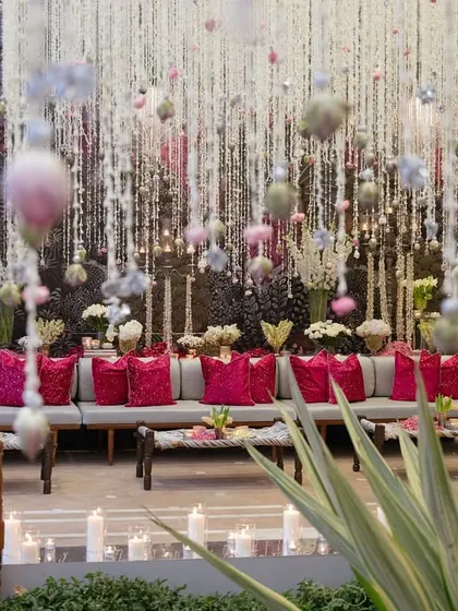A daytime event in Udaipur featuring thousands of suspended floral strings, creating a magical, swaying canopy over the guest seating and bar areas.