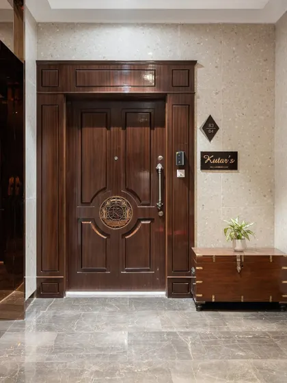 The entrance sets the tone for the entire home. We designed this grand wooden door with intricate paneling and a custom emblem to create a timeless and stately first impression, reflecting the heritage and elegance of the family within.