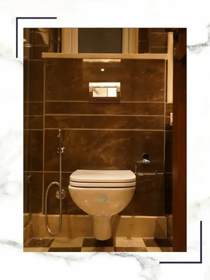 We provide the epitome of sophistication with our premium washroom designs. This image shows a wall-mounted WC set against dark marble tiles and a checkerboard floor.